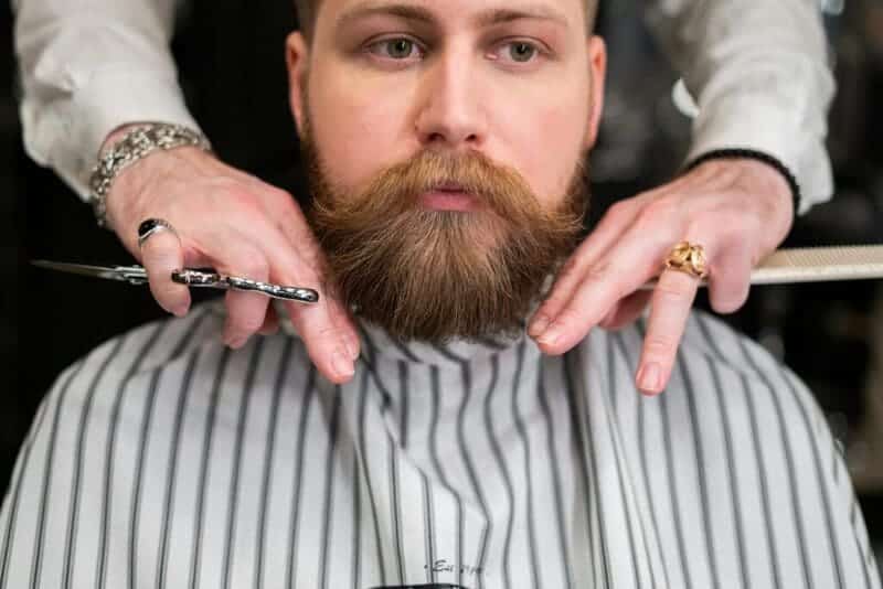 Man getting his beard trimmed. 