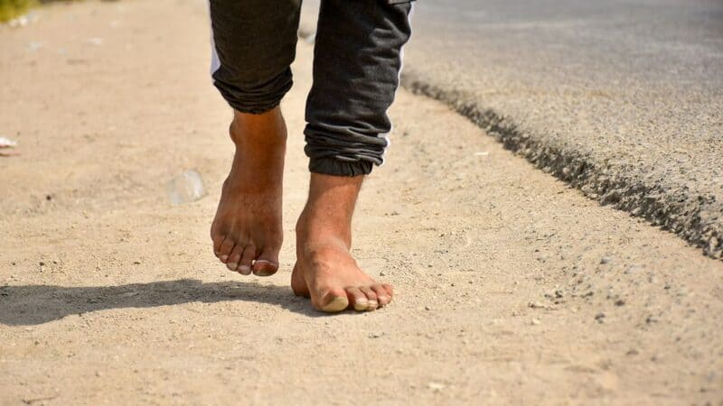 A man walking barefoot. Image courtesy of Unsplash.com.