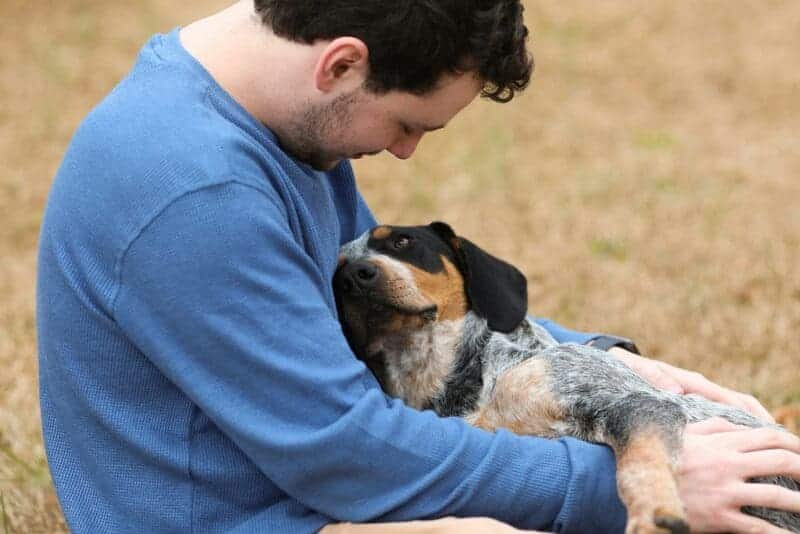 Man with dog. Photo by <a href="https://unsplash.com/@cynthiasmith" target="_blank" rel="noopener">Cynthia Smith</a> on <a href="https://unsplash.com/photos/man-in-blue-shirt-hugging-black-and-white-short-coated-dog-mWoEDIeWQWc" target="_blank" rel="noopener">Unsplash</a>.