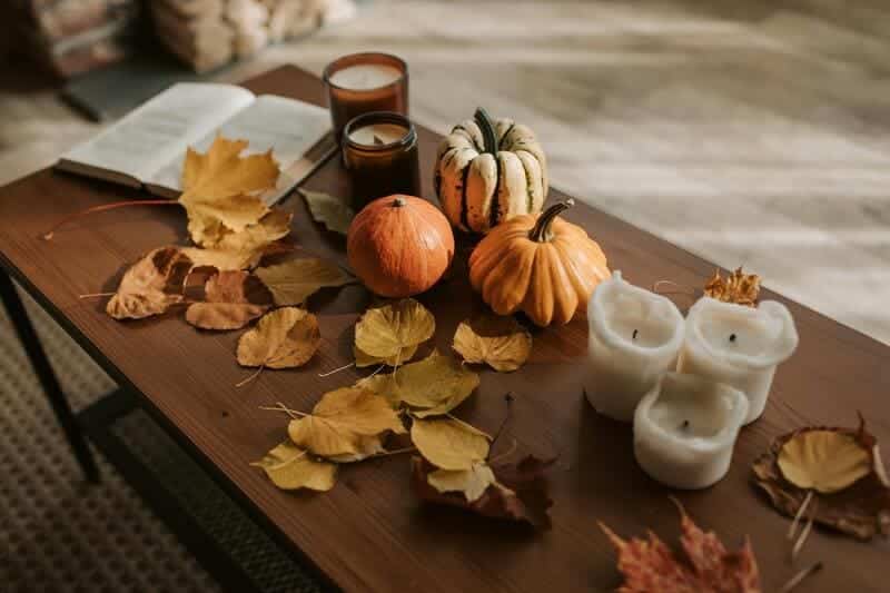 Arrangement of seasonal DIY scented candles and pumpkins