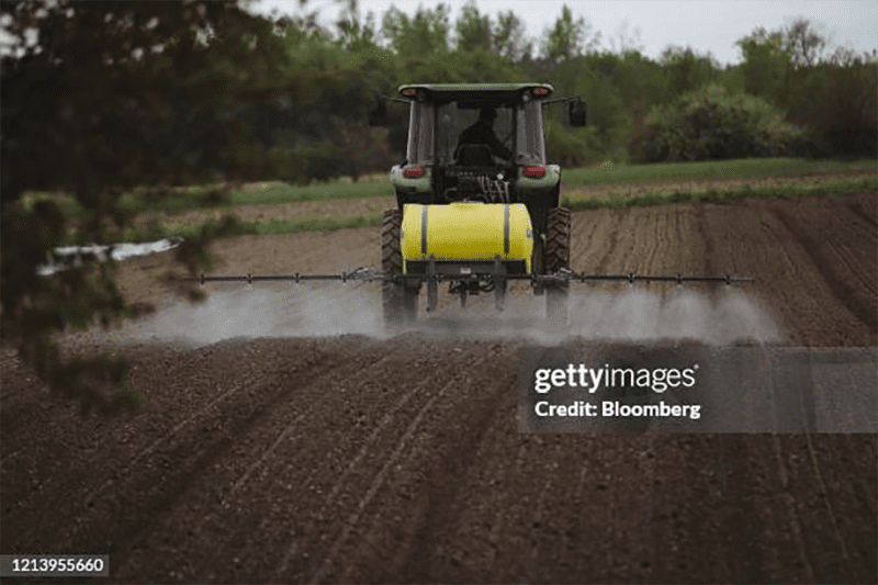 Farmer using a tractor to spray pesticide. The EPA recently issued a pesticide ban on Dacthal.