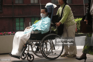 A patient with Alzheimer's disease being pushed in a wheelchair in Tokyo, Japan.