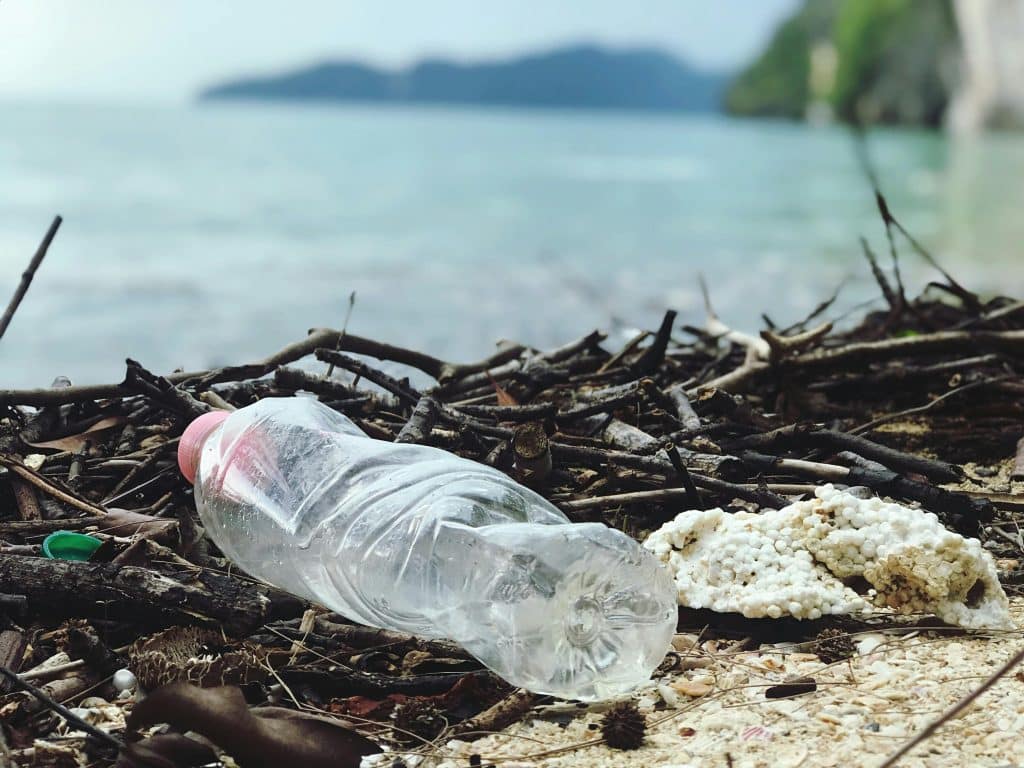 Discarded plastic bottle on a Malaysian beach, highlighting environmental pollution.