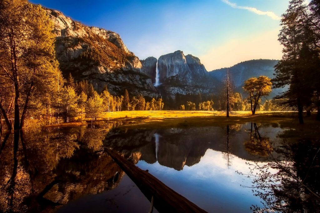 Scenic view of Yosemite National Park showcasing a waterfall and clear reflections in tranquil water.