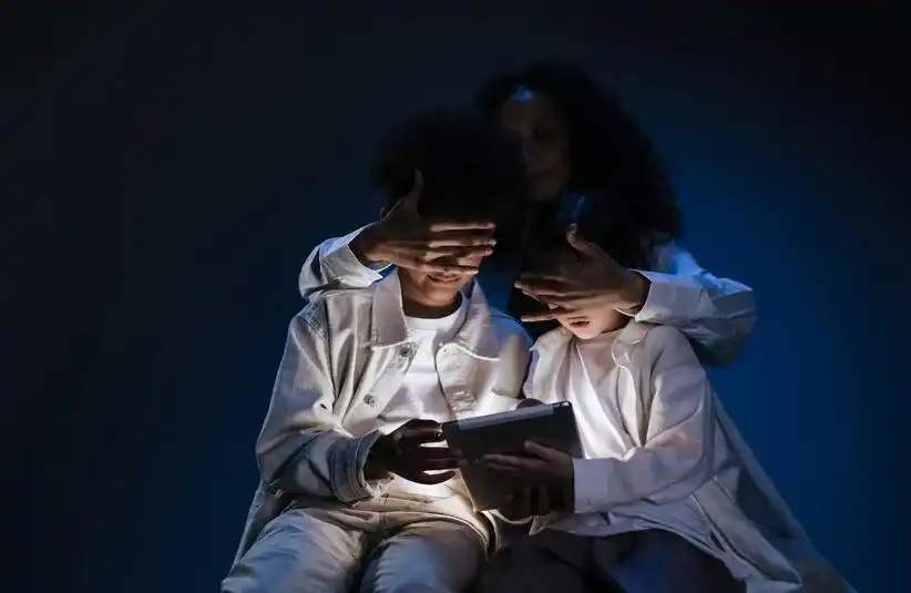 Parent shielding their children from a tablet