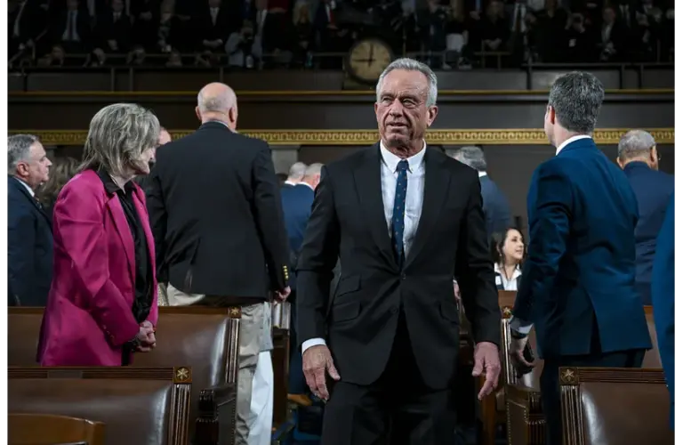 RFK Jr. standing as he walks down the aisle in the senate. A judge has blocked his latest moves.