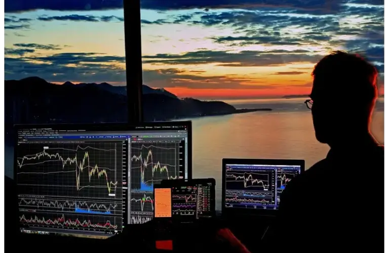 BlackRock stock dropped significantly today. Trader analyzing charts at sunset.