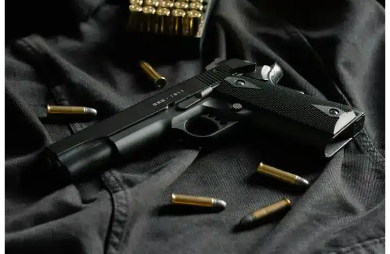 Image of a handgun on a piece of black cloth surrounded by bullets — a recent shooting in a Detroit Synagogue happened