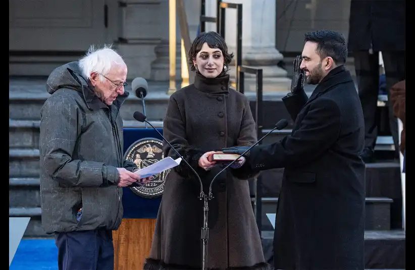 Sanders, person in a winter coat reads a paper at a podium, while Mamdani, another performs an oath with a hand raised, supported by a person holding a book. The setting appears formal and ceremonial, evoking a sense of solemnity and importance.