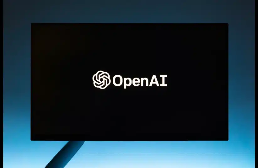 A black screen displays the OpenAI logo and text, set against a gradient blue background. The tone is modern and tech-focused.