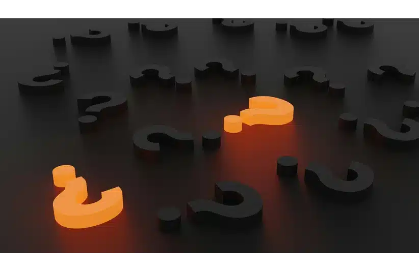 Black question marks are scattered on a dark surface, with two glowing orange, creating a dramatic and mysterious atmosphere.