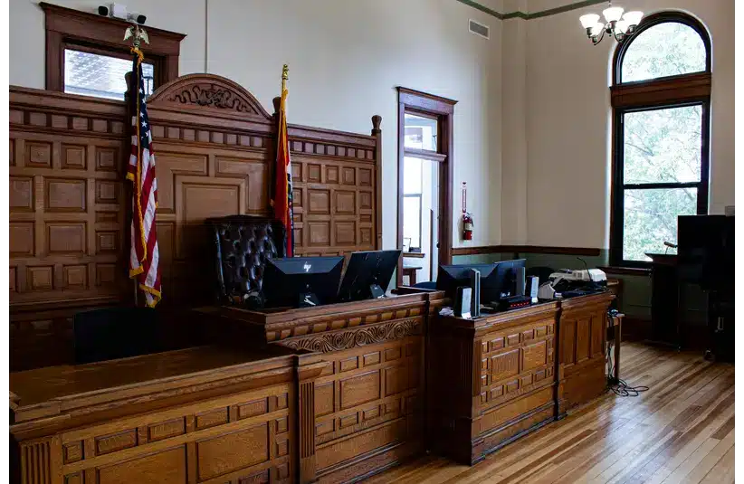 An American Courtroom with American Flags on either side of the Judge's chair, currently not in session.
