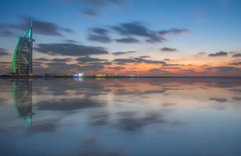 Twilight reflecting on the beach of Dubai's beautiful cityscape, UAE, captures the iconic Burj Al Arab hotel
