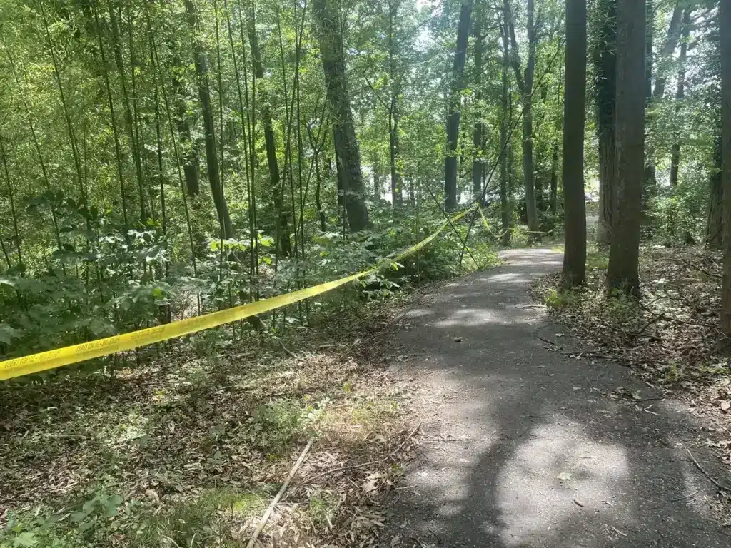 Image of a trail in Bowie, MD, tapped off with police tape for the scene of a small plane crash.