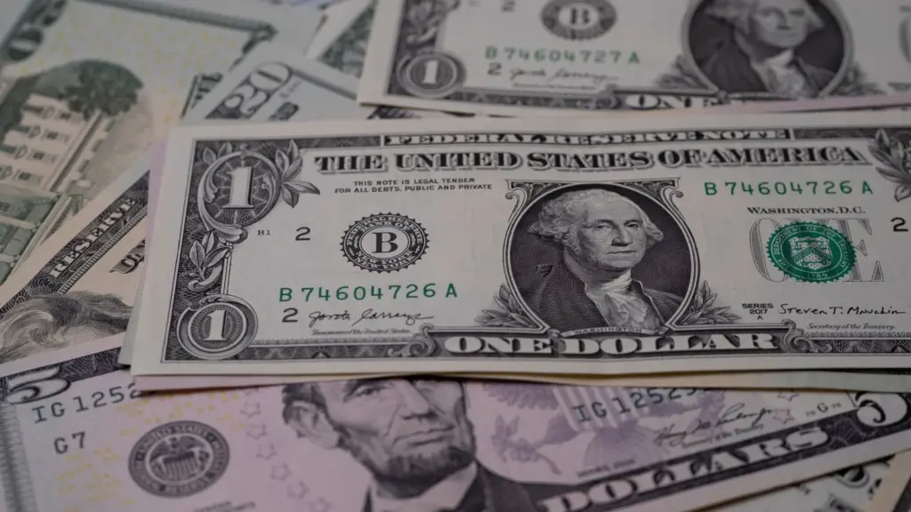 Representing the $24 billion frozen assets from Iran: A close-up image of various US dollar bills, prominently featuring a one-dollar bill with George Washington. The scene conveys a sense of financial currency.