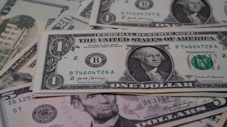Representing the $24 billion frozen assets from Iran: A close-up image of various US dollar bills, prominently featuring a one-dollar bill with George Washington. The scene conveys a sense of financial currency.