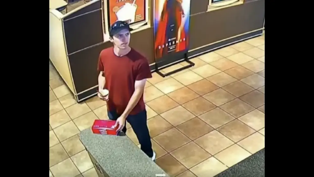 CCTV still of Tyler James Robinson in a red shirt and black hat at a Dairy Queen shortly after the Assassination of Charlie Kirk